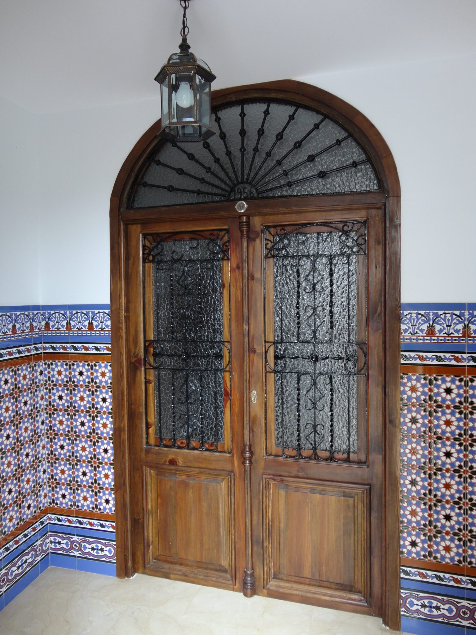 Portal de casa con jambas y arco revestidos de cerámica artesana