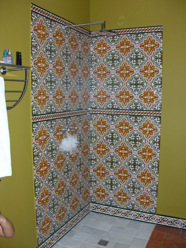 Baño con panel artesano en la ducha y zócalo decorado