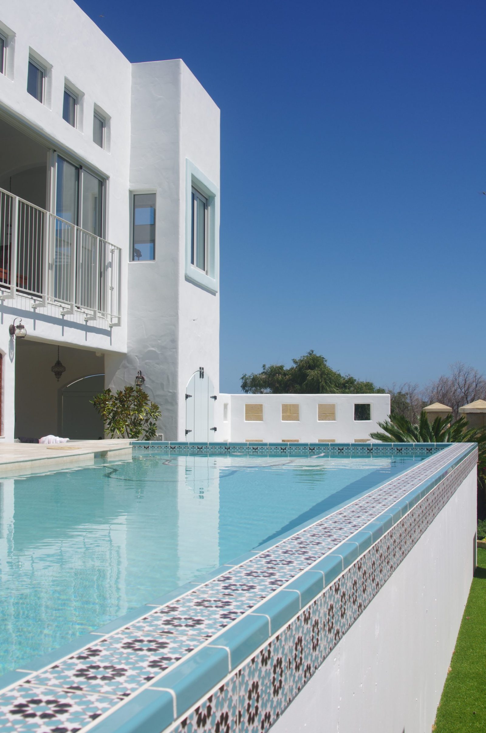 Piscina con borde y solárium revestidos de cerámica artesana