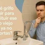 Hombre pensativo frente a un lavabo observa dos grifos contrastantes: uno viejo y deteriorado, otro moderno y brillante. A la izquierda, el título “¿Qué grifo elegir para sustituir ese grifo viejo que ya no soportas?” aparece en tipografía clara sobre un fondo beige con formas curvas azuladas, destacando el dilema de renovación en el baño.