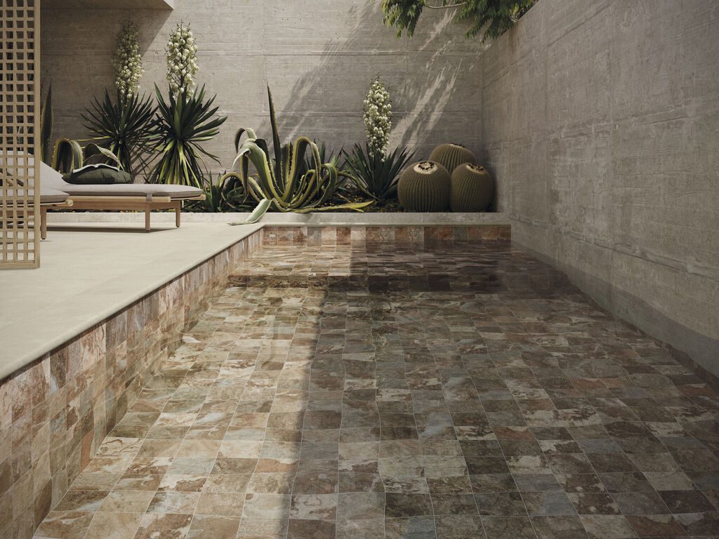 Piscina con porcelánico efecto piedra Sinai Terra 15x15 y borde skimmer de Cifre Cerámica